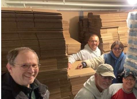 Volunteers unload boxes from Green Bay Packaging donation